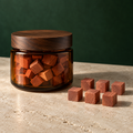 Precision-cut U.S.-grown eastern red cedar cubes in a square amber-glass jar